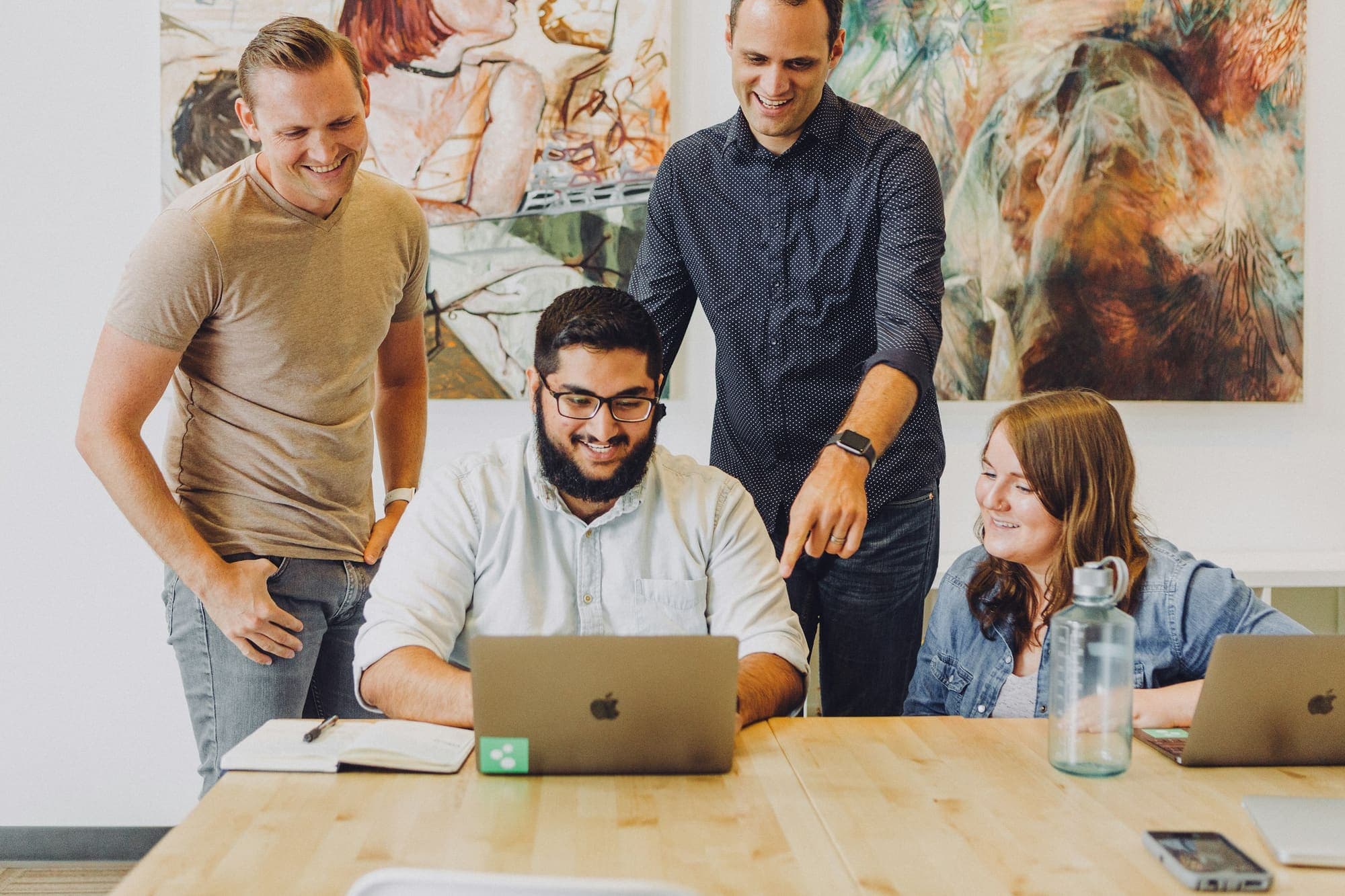 Team reviewing a design on a laptop around a table