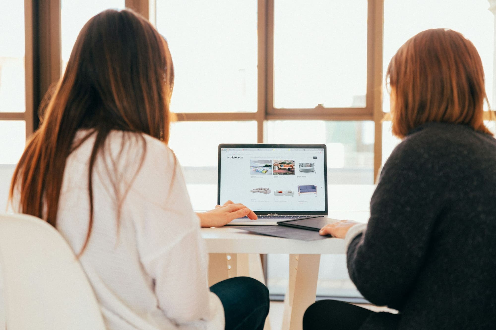 Two people discussing a website on a laptop