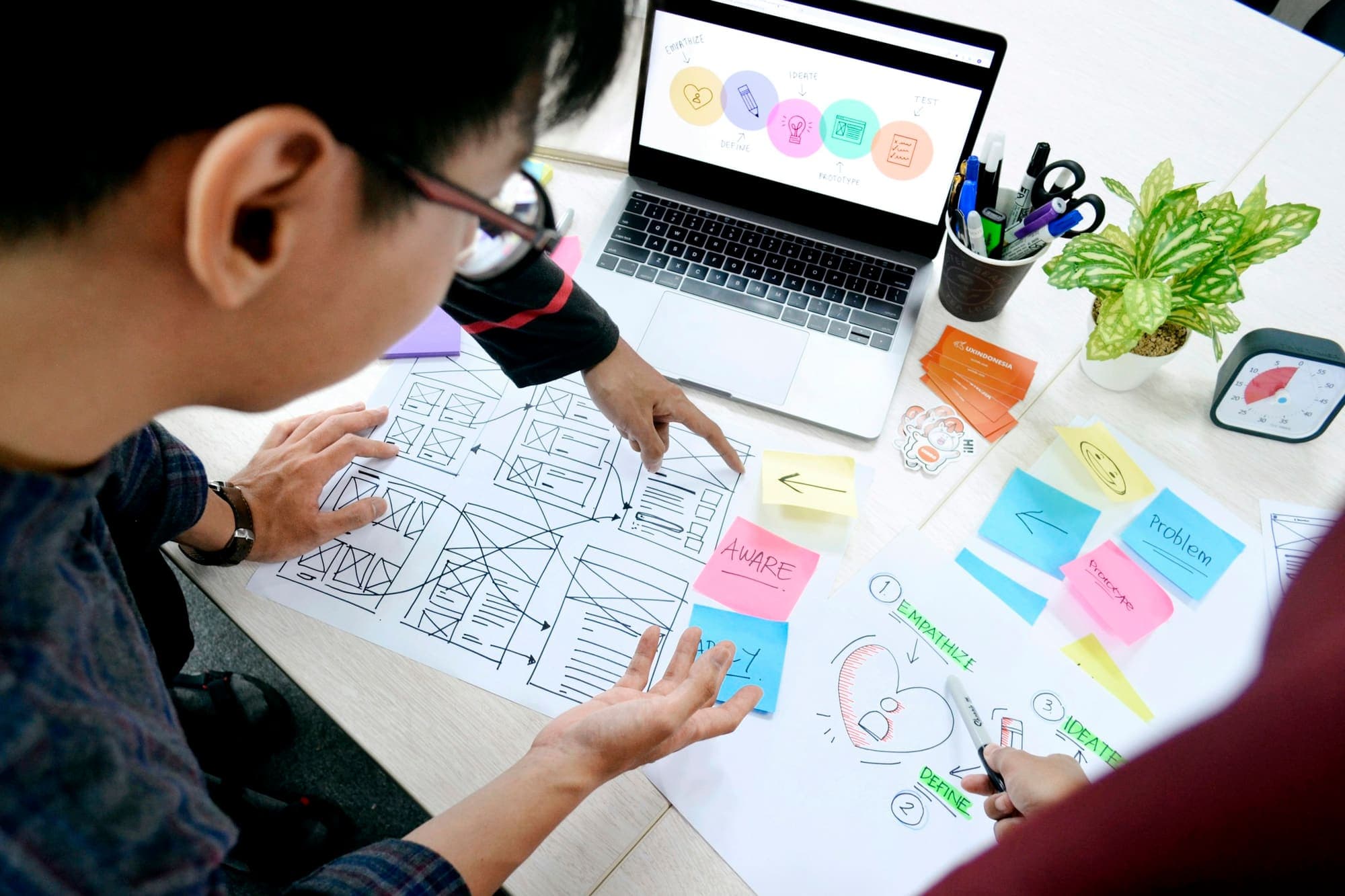 Designer sketching website wireframes at a desk